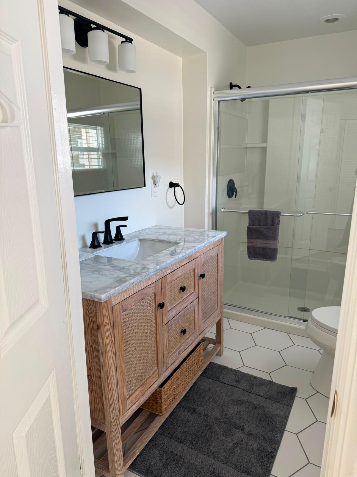 Bathroom with marble vanity and glass shower after deep cleaning