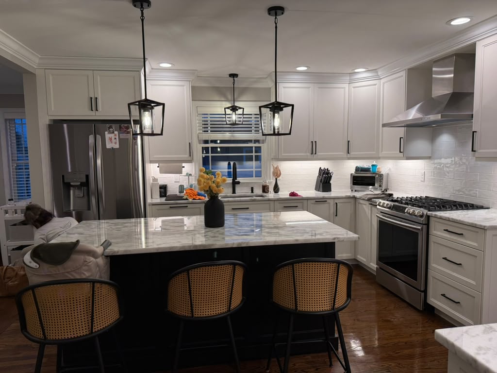 Kitchen with marble island, cane stools and pendant lanterns
