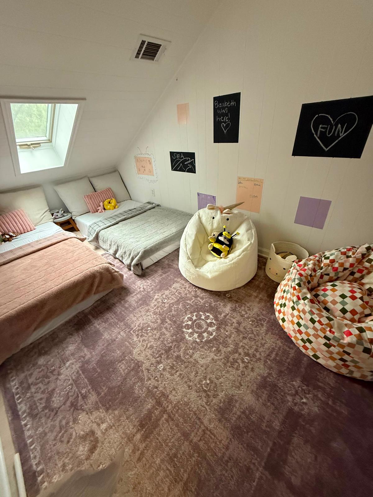 Tidy attic sleeping area with beds and play space