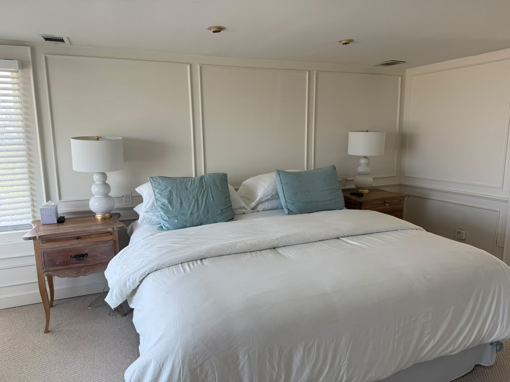 Bedroom with paneled walls and matching lamps