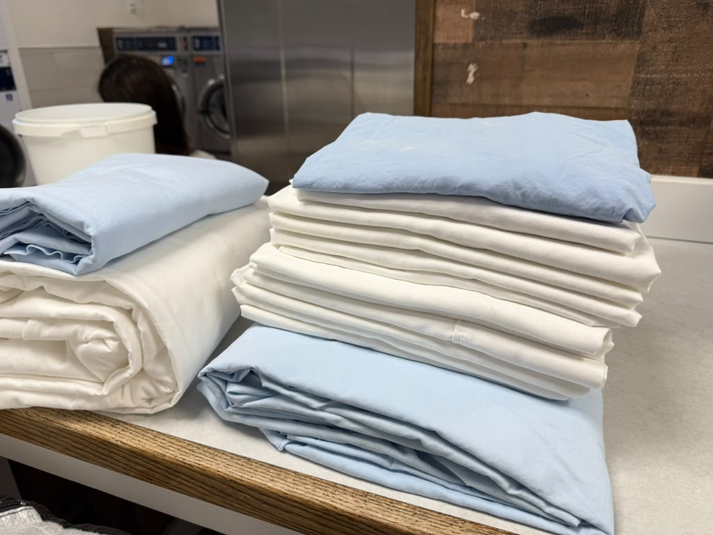 Folded white and blue bed linens ready for use